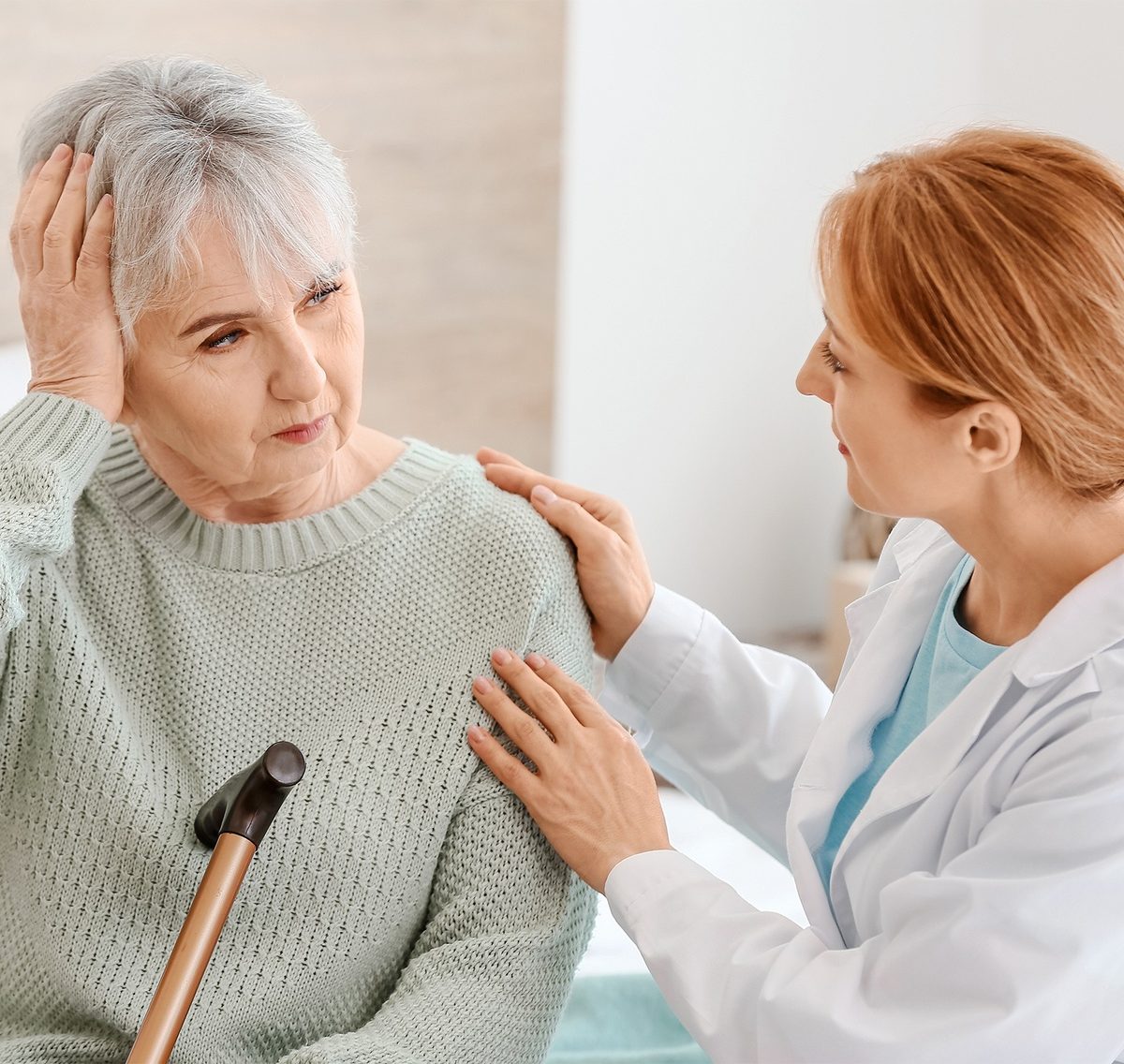 Caregiver comforting a senior woman at home